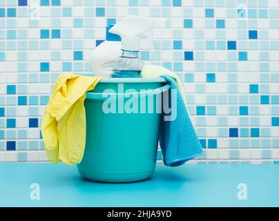 Cleaners and detergents in bucket, accessories for cleaning various surfaces and rooms blue background Stock Photo