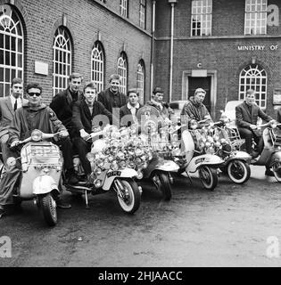 Mods wearing suits and parka's on Motor Scooters covered with extra lights and wing mirrors, pose for a group picture in Peckham. 7th May 1964. Stock Photo