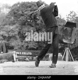 Filming the golf scene for 'Goldfinger' at Stoke Park golf course near Stoke Poges, Buckinghamshire, were Sean Connery ( James Bond ) Gert Frobe ( Goldfinger ) and Harold T Sakata who is better known as ' Tosh Togo ' in the Wrestling World. Harold is playing the part of the caddy for this scene.In the film James Bond and Goldfinger play for a £5000 stake. The game is crooked from the start to finish, but Bond wins in the end of course.  21st May 1964 Stock Photo