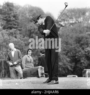 Filming the golf scene for 'Goldfinger' at Stoke Park golf course near Stoke Poges, Buckinghamshire, were Sean Connery ( James Bond ) Gert Frobe ( Goldfinger ) and Harold T Sakata who is better known as ' Tosh Togo ' in the Wrestling World. Harold is playing the part of the caddy for this scene. In the film James Bond and Goldfinger play for a £5000 stake. The game is crooked from the start to finish, but Bond wins in the end of course.  21st May 1964 Stock Photo