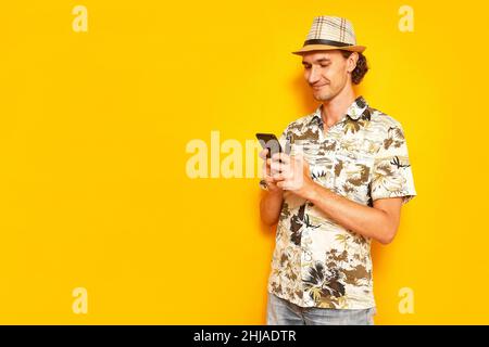 male tourist traveler holding phone in his hands, texting on smartphone with family friends, smiling Stock Photo