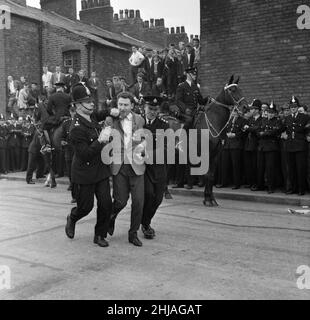 Sir Oswald Mosley visits Manchester to take part in a march organised by his British Union of Fascists supporters, Sunday 29th July 1962. When the eighty marchers gathered, an angry crowd rushed them and Mosley disappeared into a flurry of flying fists and boots and his groups banners were torn to tatters.  Police broke up the fighting mob and rescued 65-year-old Mosley but the march soon turned into a riot causing a mile of terror with fights breaking out every few yards. Many marchers fell out with bleeding faces and torn clothes. The rest were pelted with stones, coins, cabbages, tomatoes a Stock Photo