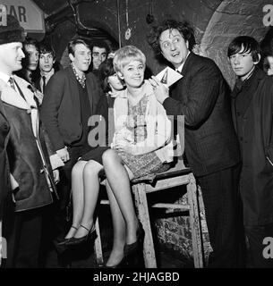 Comedian Ken Dodd was made the first honorary life member of Liverpool Cavern Club. Ken signs his application form on the back of Margaret Johnson, 19, of Anfield, Liverpool.  24th January 1964. Stock Photo