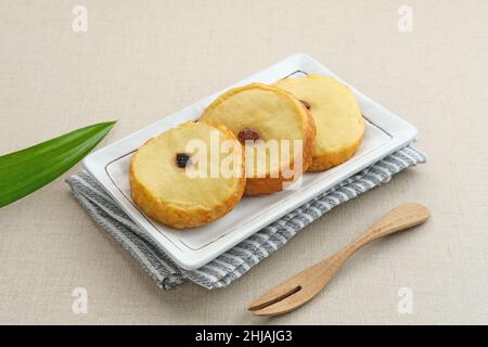 Kue Lumpur or Mud Cake, Indonesian traditional snack made from potatoes, flour, eggs and coconut milk topped with raisins. Selected focus. Stock Photo