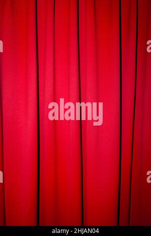 Red closed curtain with a light spot use for background Stock Photo