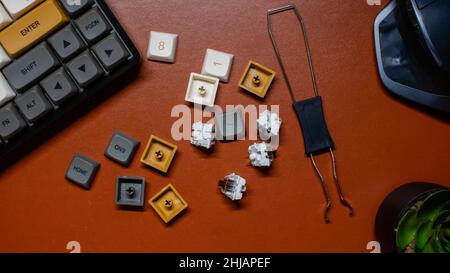 Flat layout of mechanical keyboard with key caps on brown leather background. Home office desk workspace. Business, work template. Flat lay, top view. Stock Photo