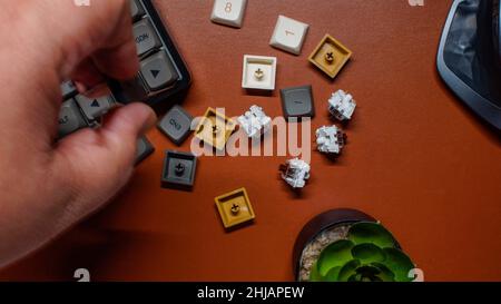 Flat layout of mechanical keyboard with key caps on brown leather background. Home office desk workspace. Business, work template. Flat lay, top view. Stock Photo