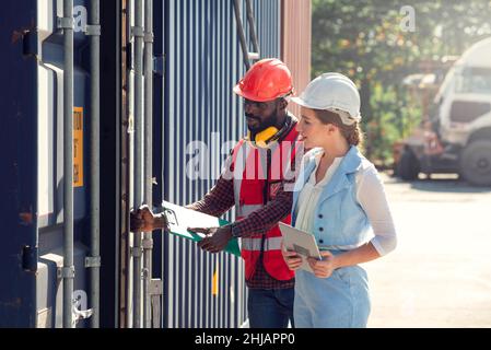 Businesswoman and engineer talking and checking loading Containers box from Cargo freight ship for import export. shipping in docks. Stock Photo