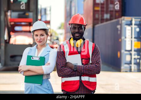 Confident foreman and worker standing with confidence and success. people working in workplace of industrial container warehouse. Stock Photo