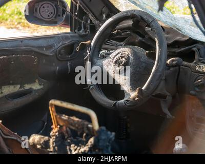 Remains of an old crashed car burned from the inside Stock Photo
