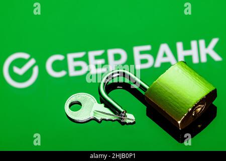 An open security lock and key on background of Sberbank logo in mirror reflection Stock Photo