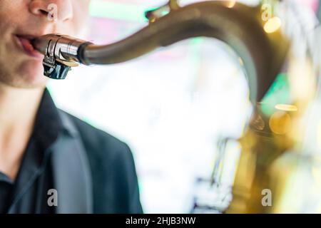 saxophone in hands close-up man in black outfit Stock Photo