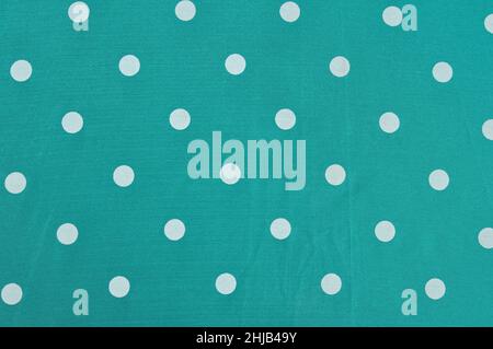White dot pattern over green background on fabric Stock Photo
