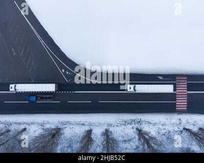 Two trucks on the road view from the air in winter Stock Photo