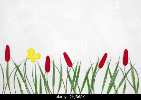 Artificial decorative green grass with yellow butterfly on silvery white shabby texture. Cute spring or summer background with copy space Stock Photo