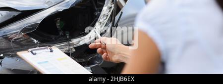 Insurance agent inspects damage to car after accident closeup Stock Photo