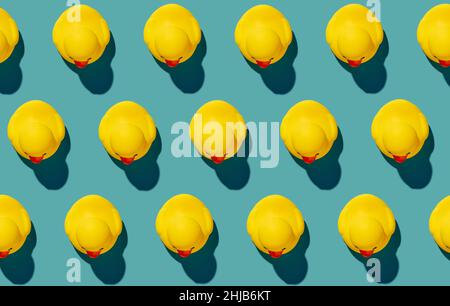 Yellow rubber duck toys pattern on isolated seamless blue background. Bright conceptual banner design. Stock Photo