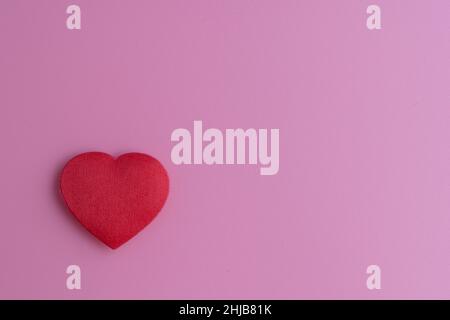 Valentine's day wallpaper for your phone or computer, especially for ladies. A light pink background with a small, red heart on the left side. It is r Stock Photo