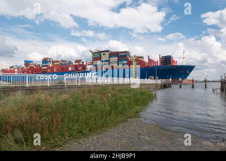 Doel, Belgium, August 17, 2020, The container ship Cosco Shipping from Hong Kong, sails very close to the pier of the polder village of Doel in Belgiu Stock Photo