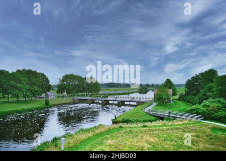 Drone view of the river Vecht, green grass, trees, beautiful blue sky and cycle path through the Vecht valley. Bridge and weir in the river. Dalfsen N Stock Photo