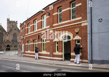 Men renovating brick building wall, Abergavenny, Wales, UK Stock Photo