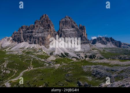 The mountain hut Rifugio Auronzo, located at the foot of the south faces of the mountain group Tre Cime di Lavaredo, Paternkofel (right). Stock Photo