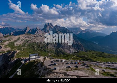 The mountain hut Rifugio Auronzo, located at the foot of the south faces of the mountain group Tre Cime di Lavaredo, Paternkofel (right) in the distan Stock Photo