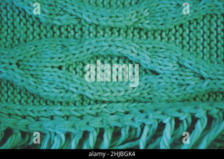 Comfy cozy scarf from natural green yarn and wool knit into beautiful patterns. Stock Photo