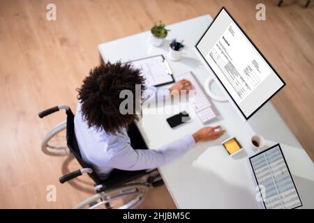 African Accountant With Disability Working On Computer In Wheelchair Stock Photo