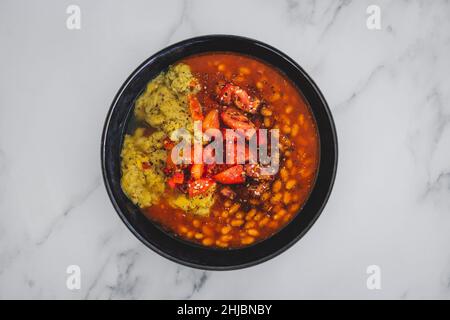 vegan baked beans and chickpea flour frittata with tomato salsa topping, healthy plant-based food recipes Stock Photo