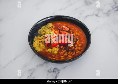 vegan baked beans and chickpea flour frittata with tomato salsa topping, healthy plant-based food recipes Stock Photo