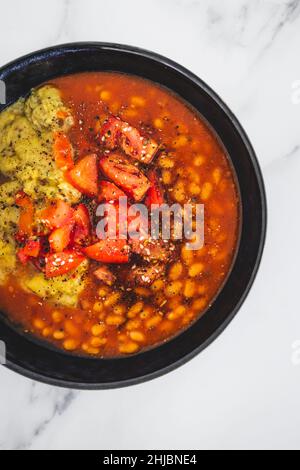 vegan baked beans and chickpea flour frittata with tomato salsa topping, healthy plant-based food recipes Stock Photo