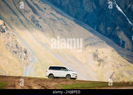 Mitsubishi Delica Space Gear driving on off road on summer mountain background. Delica is a range of trucks and multi-purpose vehicles produced by Stock Photo