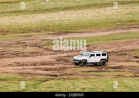 White Hummer H2 SUV Car On Off Road In Spring Mountains Landscape In Georgia. Landscape Of Gorge At Spring Season Stock Photo