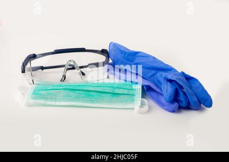Shot of a mask ,glove and goggles lying on top of a white table Stock Photo