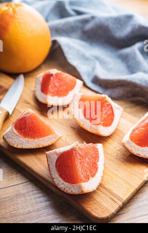 Sliced citrus fruit. Chopped fresh grapefruit on a cutting board. Stock Photo