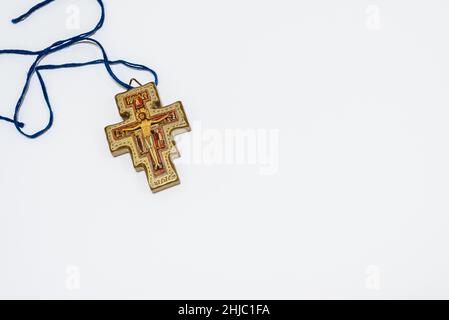 golden San Damiano cross in a blue cord on a white background, Frederikssund, Denmark, January 27, 2022 Stock Photo