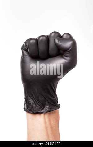 Raised fist in black rubber glove isolated on white background. Clenched fist as a symbol of protest, closeup Stock Photo