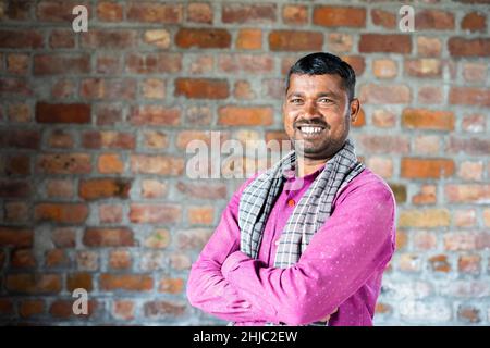 Smiling confident construction worker turns by looking camera at workplace - concept of manual labor and happiness Stock Photo