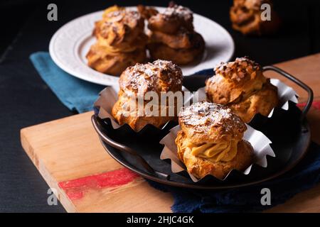 Food concept Homemade Caramel Choux a la cream or Choux cream puffs on dark background with copy space Stock Photo