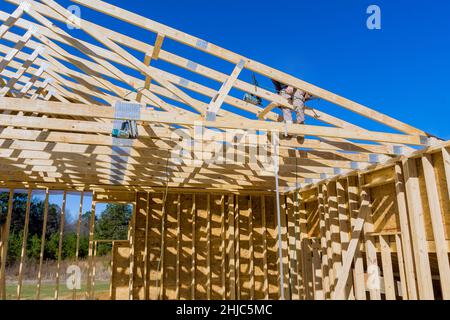 Roofer carpenters works on roof at height workers nailing wood beams the roof new building construction Stock Photo