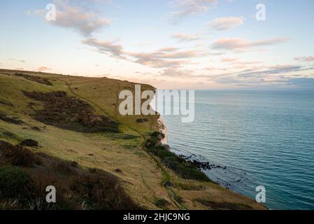 Beautiful scenery of white cliffs along blue sea under dramatic sky Stock Photo