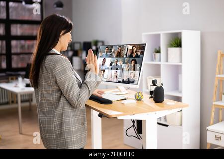 Video Conference Call Using Electric Adjustable Height Standing Desk Stock Photo