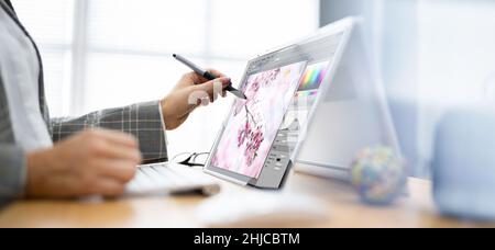 Graphic Designer Artist Drawing On Digital Tablet Or Hybrid Laptop Stock Photo