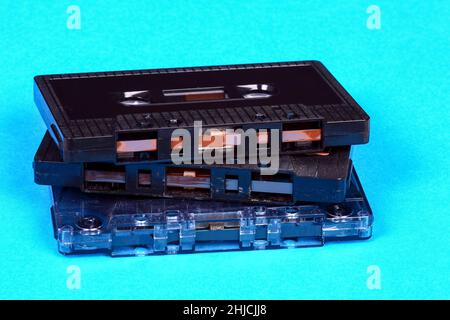 Stack of old vintage retro audio cassette tapes isolated on a blue background Stock Photo
