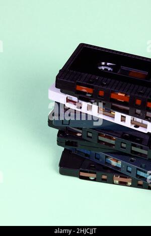 Stack of old vintage retro audio cassette tapes isolated on a green background Stock Photo