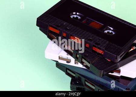 Stack of old vintage retro audio cassette tapes isolated on a green background Stock Photo