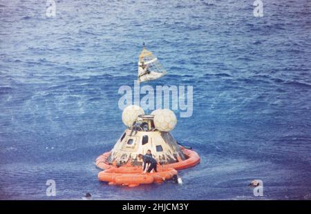 Astronaut John L. Swigert Jr., command module pilot, is lifted aboard a helicopter in a Billy Pugh helicopter rescue net while astronaut James A. Lovell Jr., commander, awaits his turn. Astronaut Fred W. Haise, Jr., lunar module pilot, is already aboard the helicopter. In the life raft with Lovell, and in the water are several U.S. Navy underwater demolition team swimmers, who assisted in the recovery operations. The crew was taken to the U.S.S. Iwo Jima, prime recovery ship, several minutes after the Apollo 13 spacecraft splashed down at 12:01:44 pm CST on April 17, 1970. Stock Photo