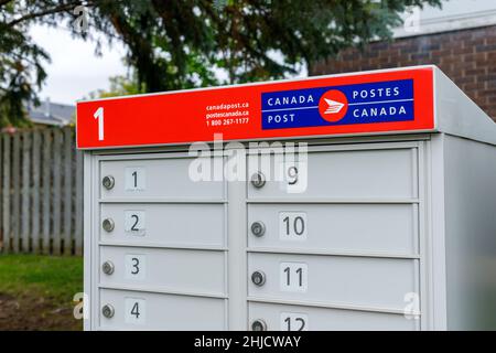 Ottawa, Canada - October, 2021: Canada Post mail boxes close up in neighborhood community with red sign in English and French Stock Photo