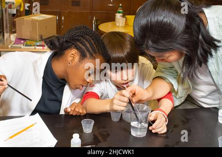 Education Elementary or Middle School Grade 6 science class DNA extraction, boy and two girls working on an experiment Stock Photo